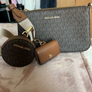 Michael Kors Crossbody Purse with change purse and AirPod case attached.